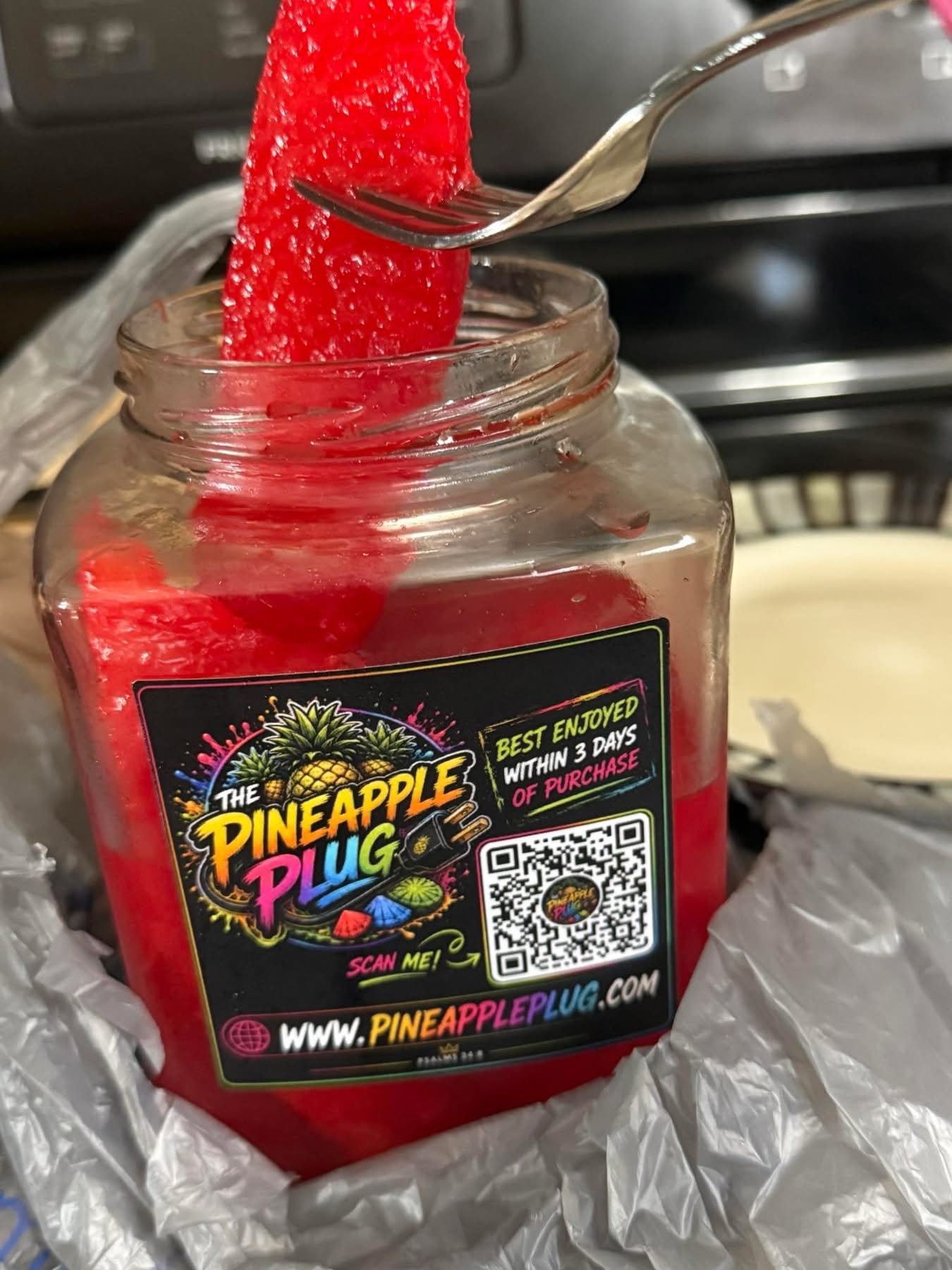 An open jar of Kick Punch flavored pineapples.
